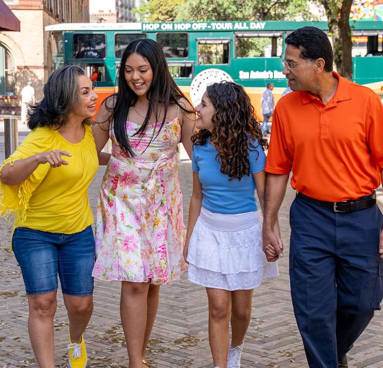 Family laughing in front of Old Town Trolley Tours bus.