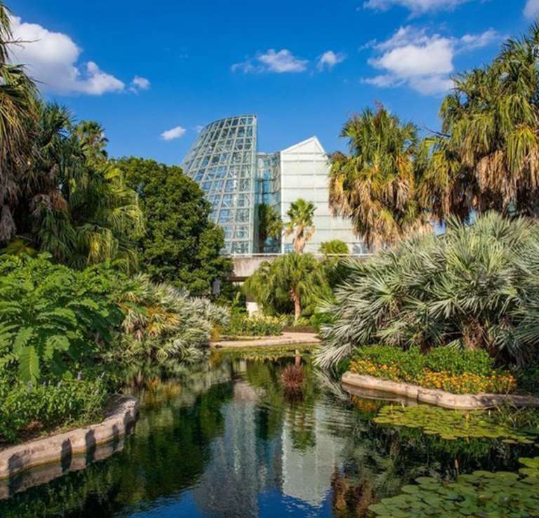Greenery around large greenhouse at botanical garden