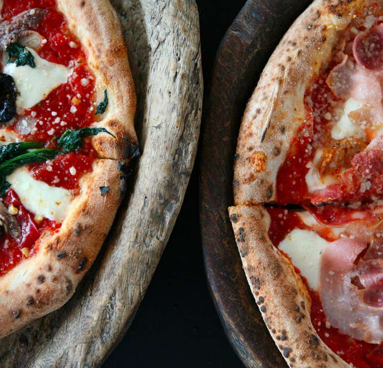 Overhead view of two pizzas side by side.