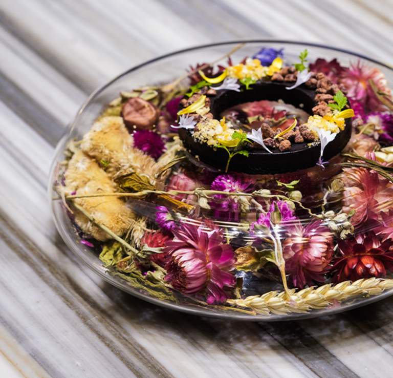 Circular plate of food adorned with florals at Nicosi restaurant in San Antonio.