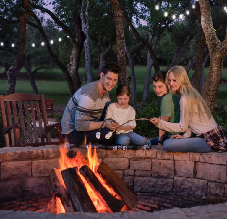 Family sitting be campfire outside