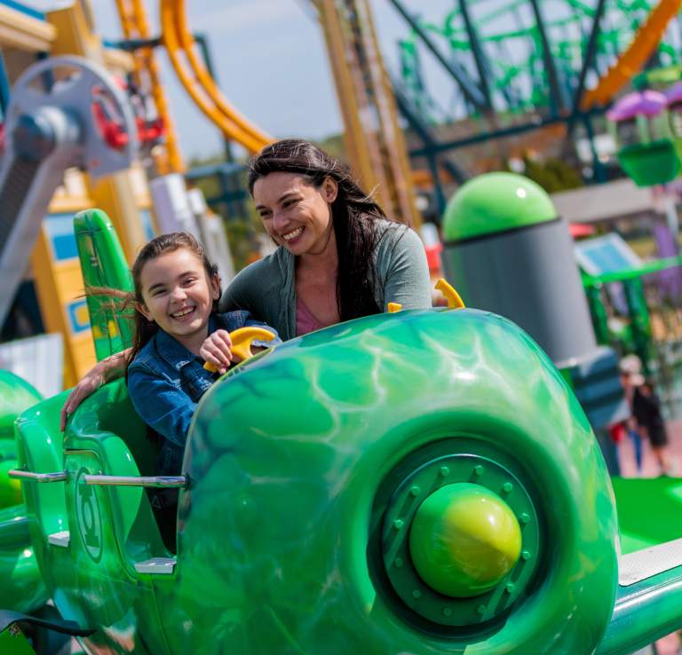 Mother and daughter smiling on Green Lantern ride at Six Flags Fiesta Texas.