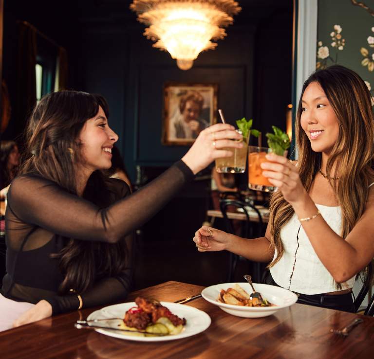 Two girls toasting their drinks