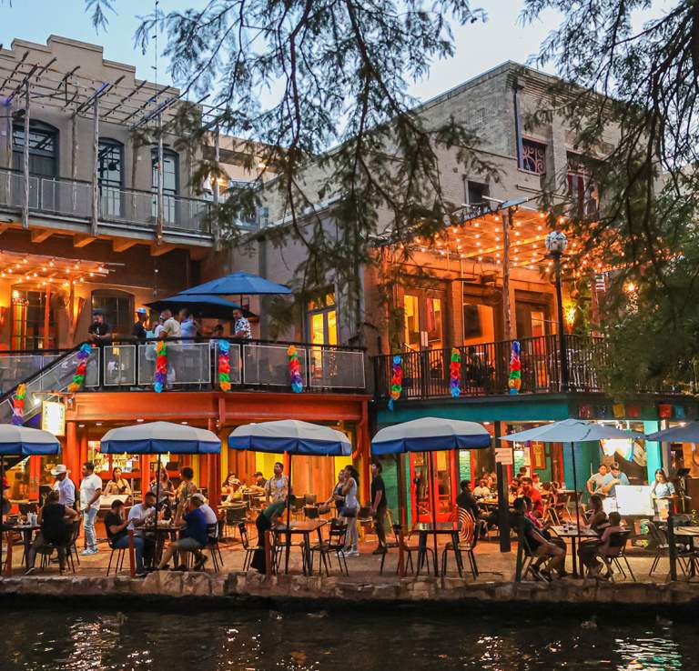 People dining along the San Antonio River Walk.