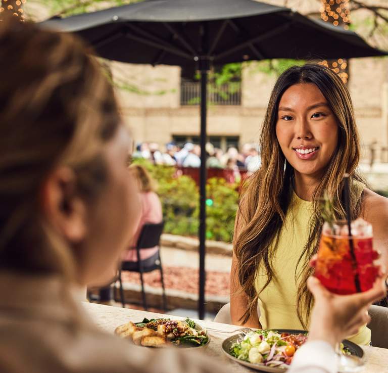 Woman accepting drink from waitress and smiling