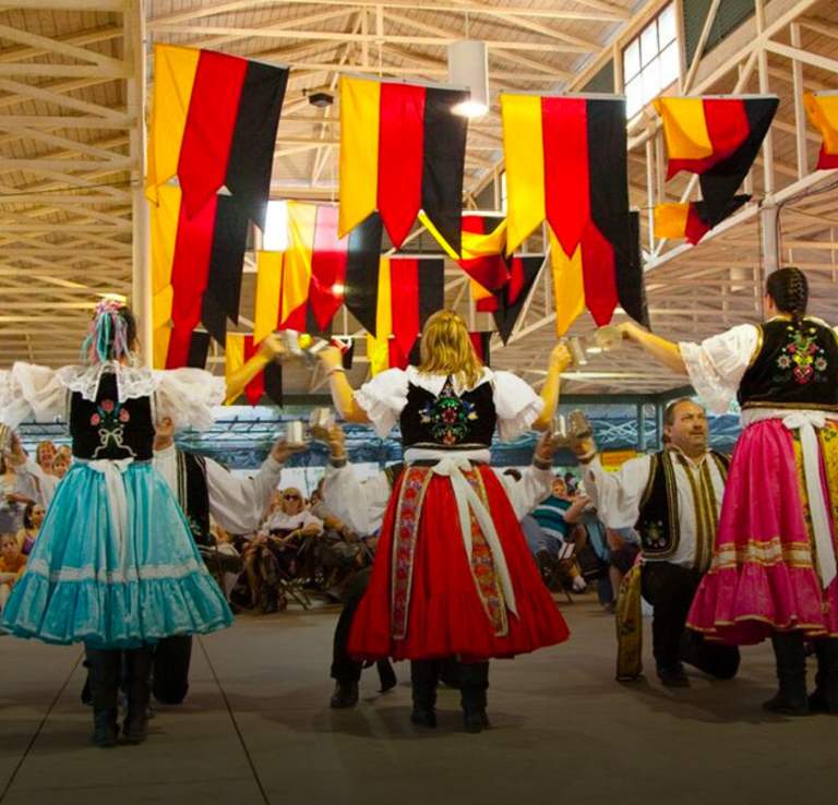 Group of people in German attire dancing.