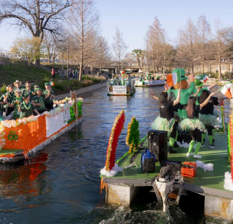 River barges decorated for St. Patrick's day floating past each other