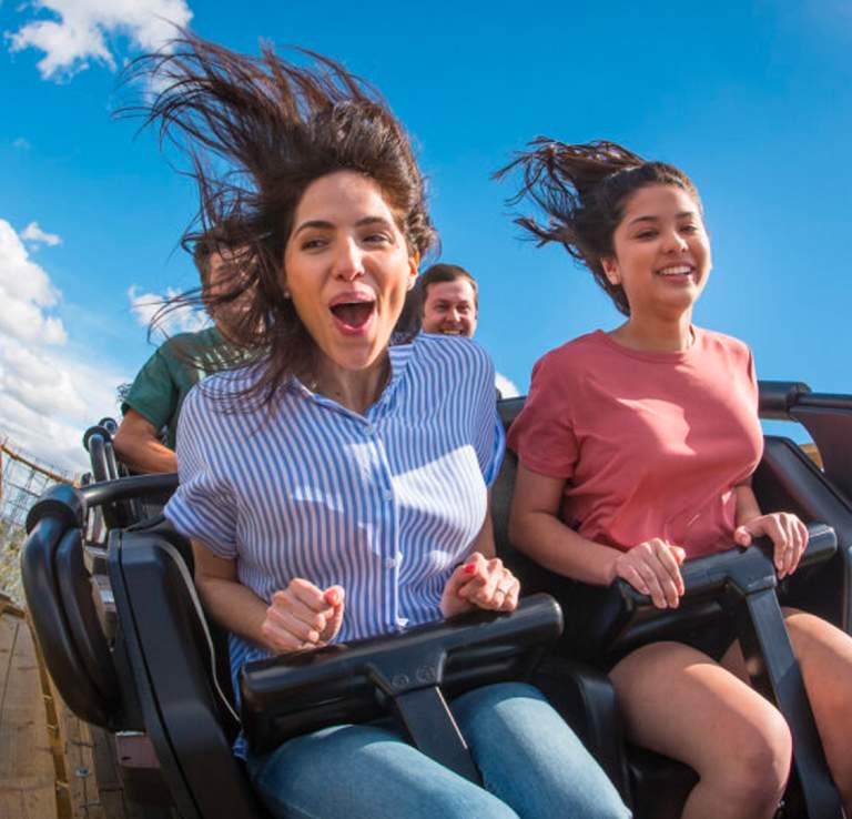 Friends on a rollercoaster going over a hill