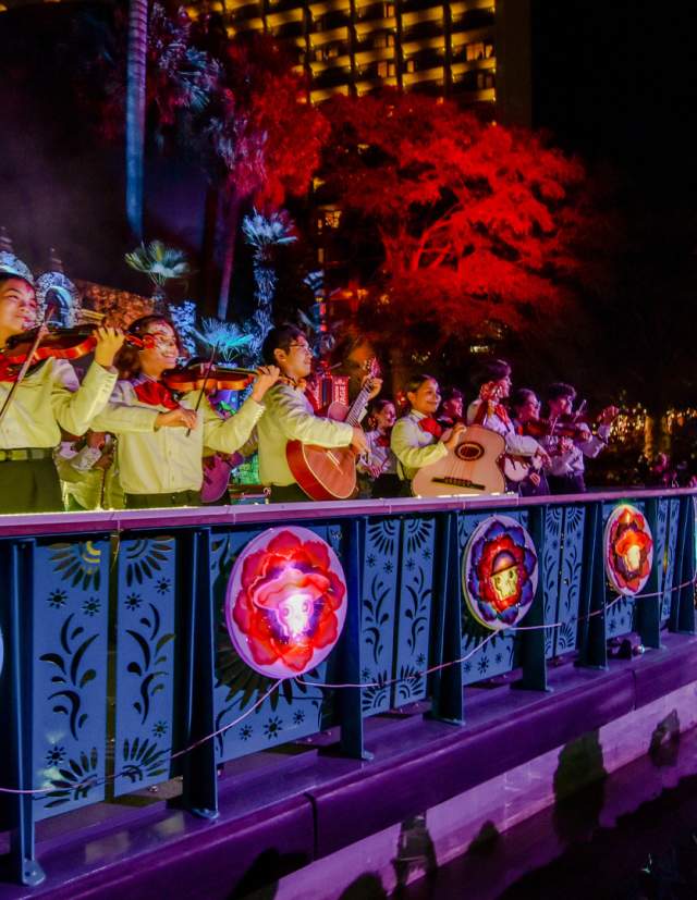Mariachi band members on a river barge drifting in the Day of the Dead River Parade.
