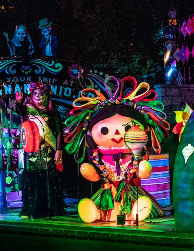 River parade float with people dressed with sugar skulls