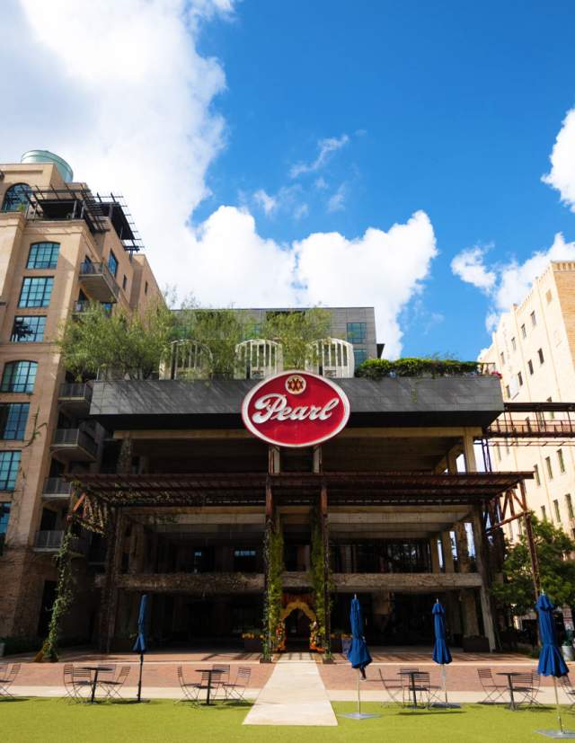Green courtyard in front of tall Pearl building