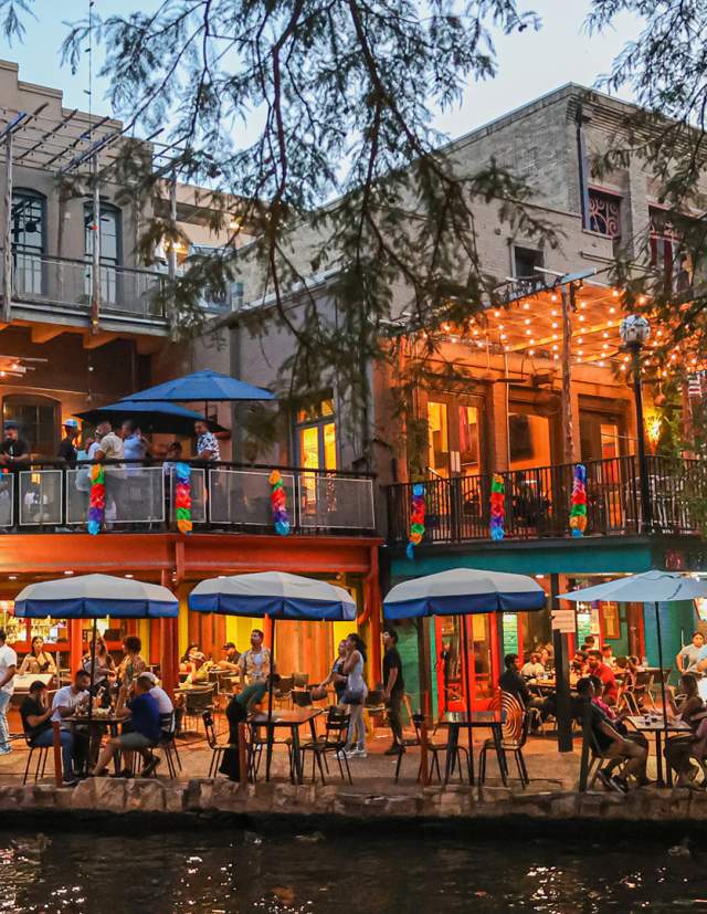 People dining along the San Antonio River Walk.