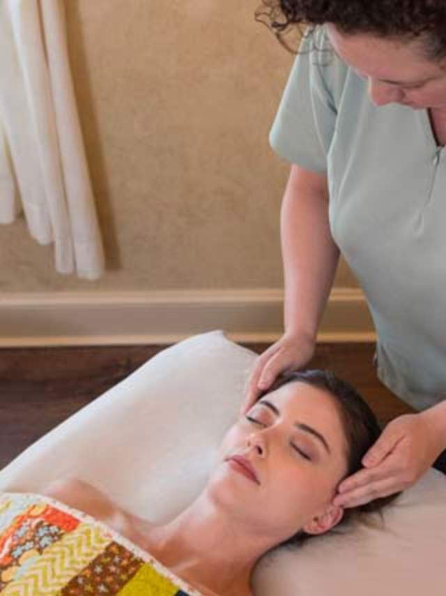 Masseuse rubbing woman's head