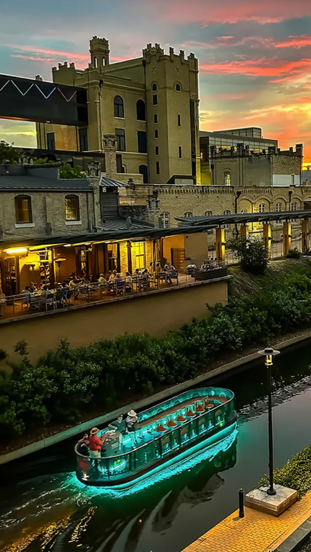 Lit up river barge at Museum Reach of San Antonio River Walk.