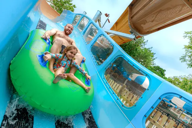 Father and daughter on waterslide together.