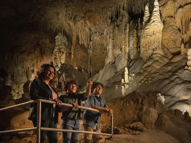 Mother and two sons exploring inside cave at Natural Bridge Caverns in San Antonio.