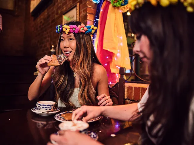Girl eating pastry dunked in hot chocolate