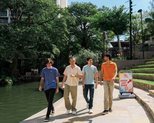 Group of men walking along River Walk in San Antonio.