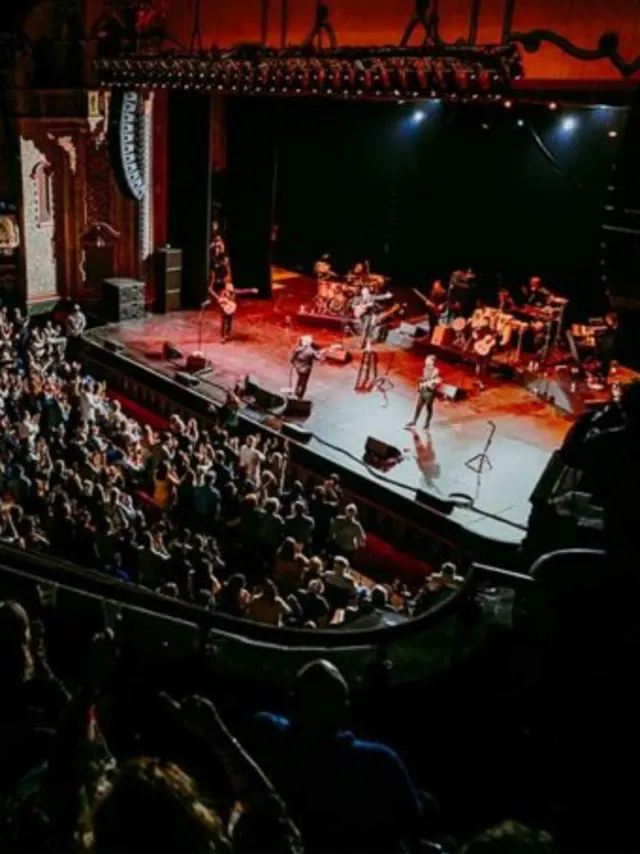 Band playing in front of crowd at large theatre