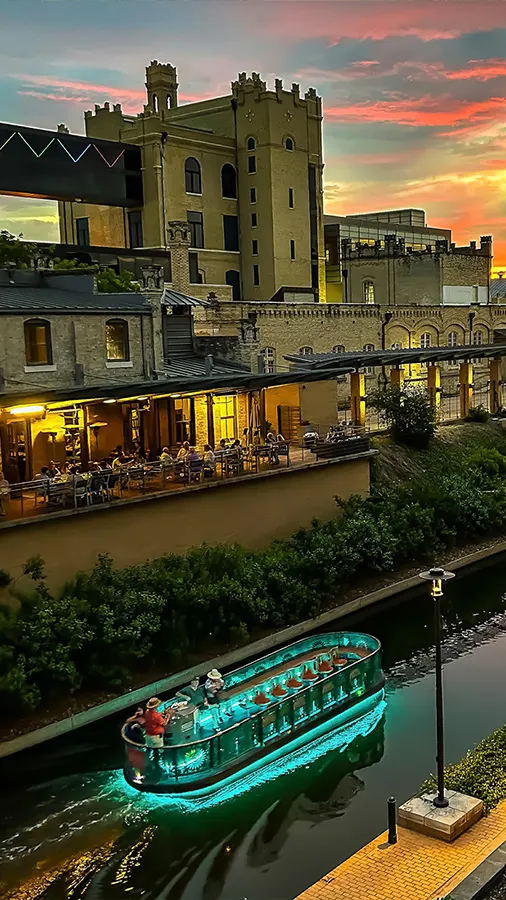 Lit up river barge at Museum Reach of San Antonio River Walk.