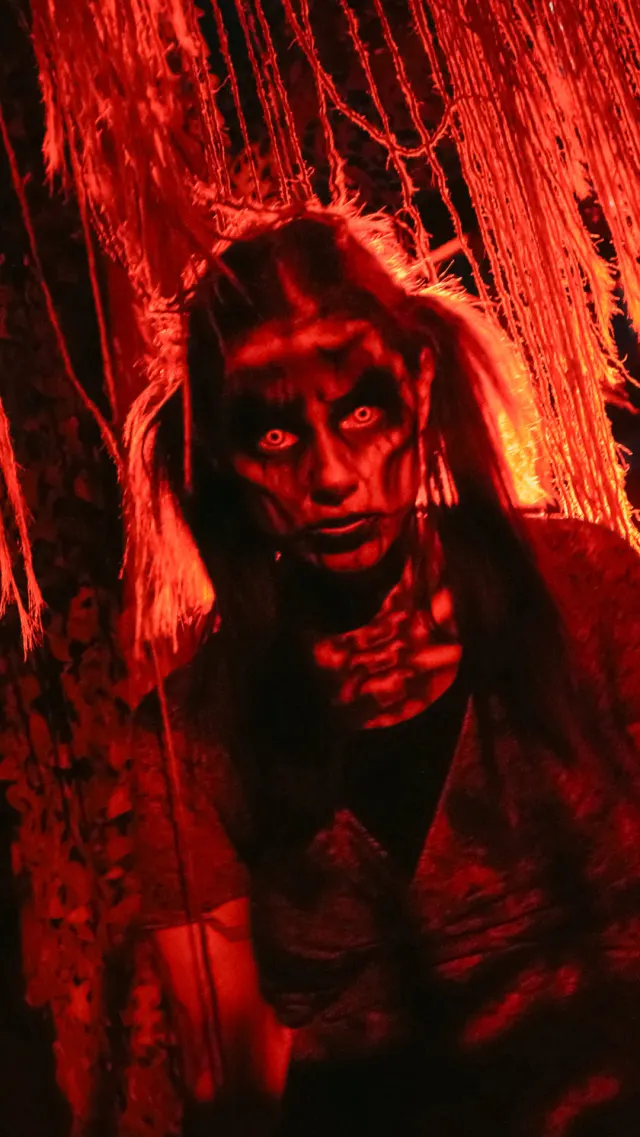 Woman in scary makeup with orange and black background at Six Flags.