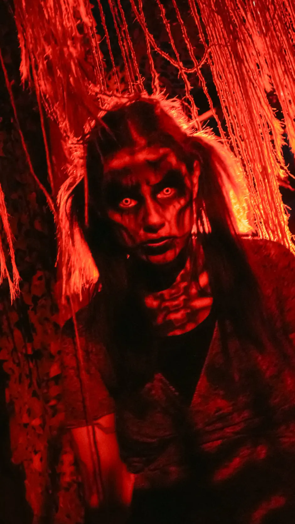 Woman in scary makeup with orange and black background at Six Flags.