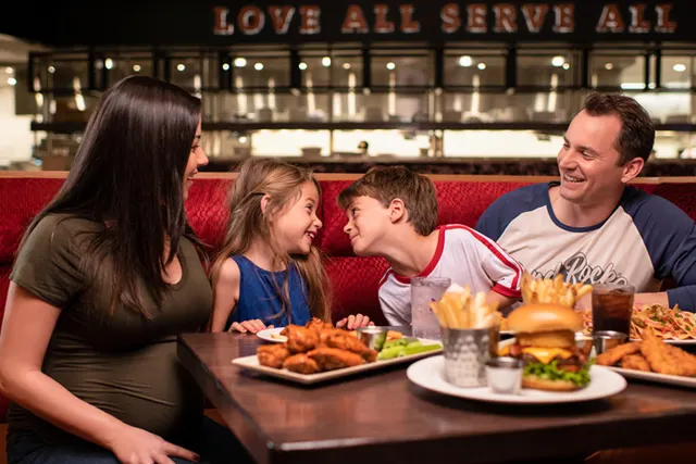 Family laughing and enjoying dinner at Hard Rock Cafe San Antonio.