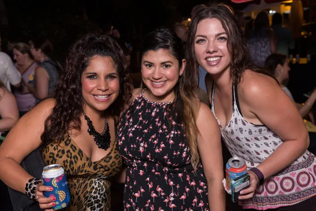 Three girls posing together and smiling.