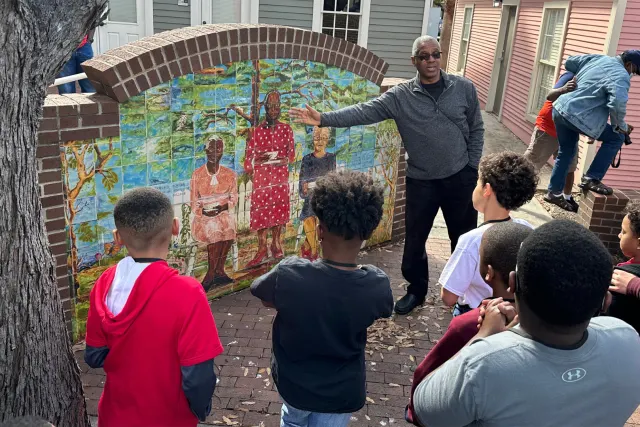 Man explaining piece of artwork to group
