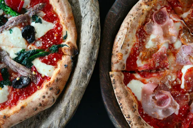 Overhead view of two pizzas side by side.