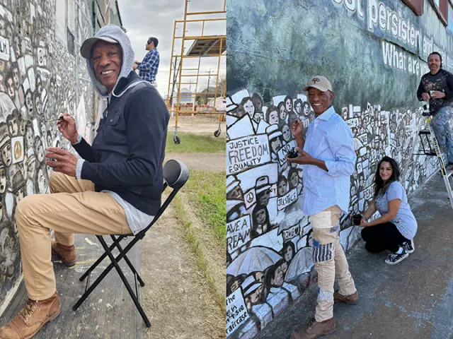 Artist Dlani Middleton painitng a mural