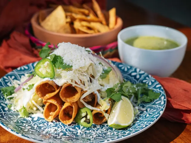 Plate of flautas topped with jalepenos and lime from Mexico Ceaty in San Antonio.