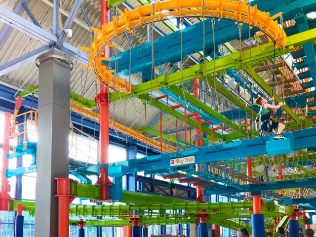 Ground-level view of LiggettVille Adventure Center multi-colored high-rise obstacle course.