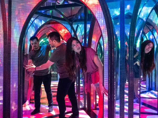 Two people inside a mirror maze searching for a way out.