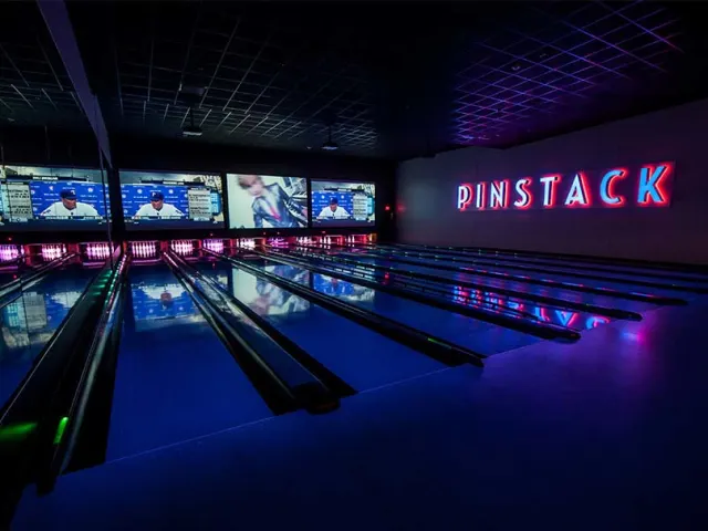 Dimly lit bowling lanes at PINSTACK in San Antonio.