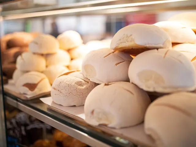 Conchas stacked on top of each other in display case at La Panaderia.