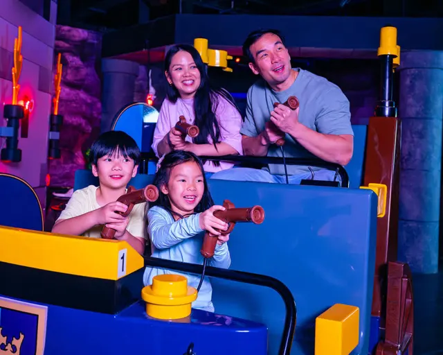 Family playing interactive game at Legoland Discovery Center.