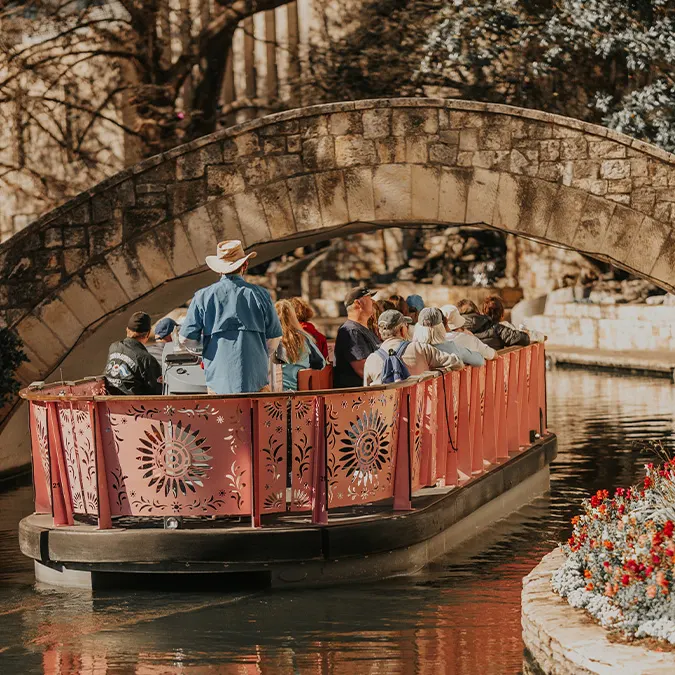 Barge carrying people floating down River Walk