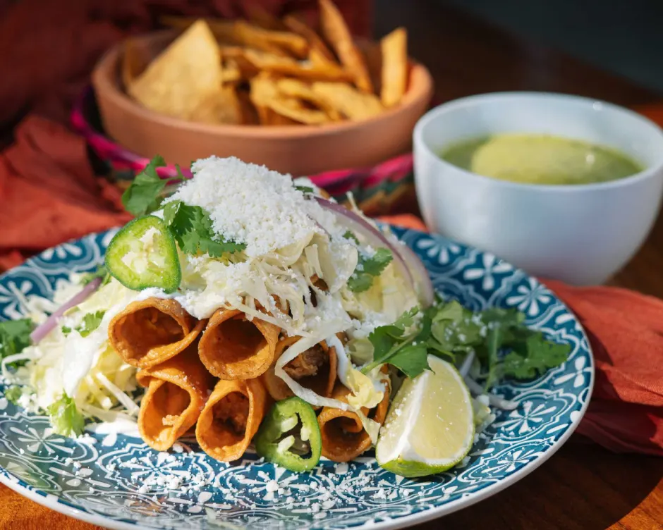 Plate of flautas topped with jalepenos and lime from Mexico Ceaty in San Antonio.