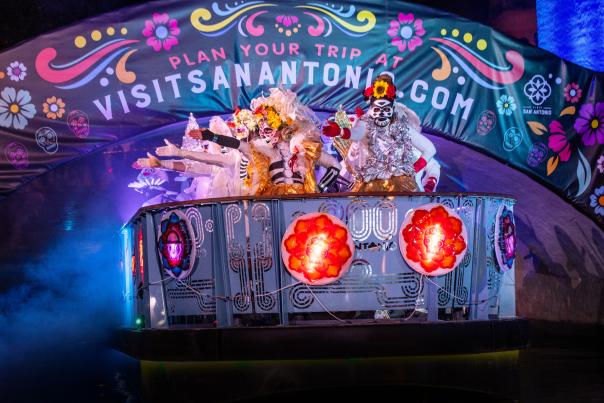 River barge with costumed dancers floating underneath a bridge
