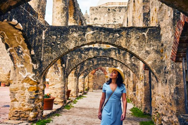 Woman walking under arches at missions