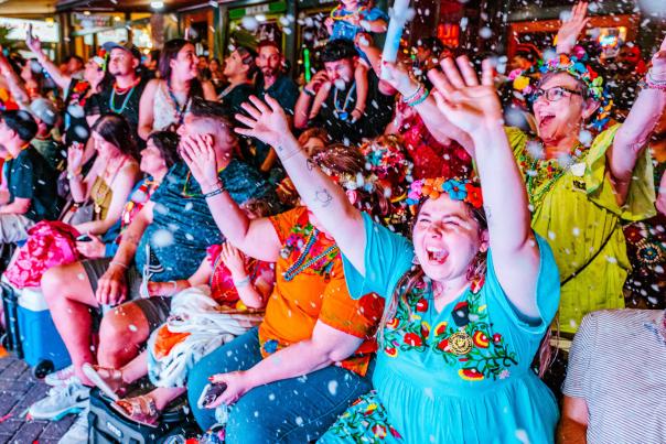 Group of people cheering with confetti at Fiesta San Antonio.