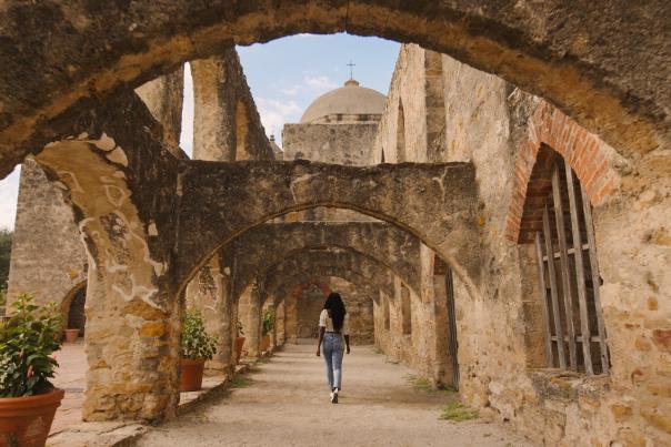 Woman walking through San Antonio Missions National Historial Park pathway