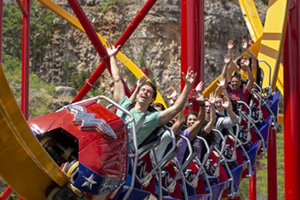 People on Wonder Woman rollercoaster with their hands in the air.