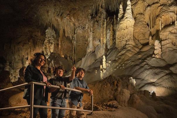Mother and two sons exploring inside cave at Natural Bridge Caverns in San Antonio.