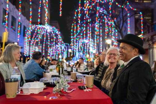 Taste of the Holidays table set up with people gathering at Houston Street in San Antonio.