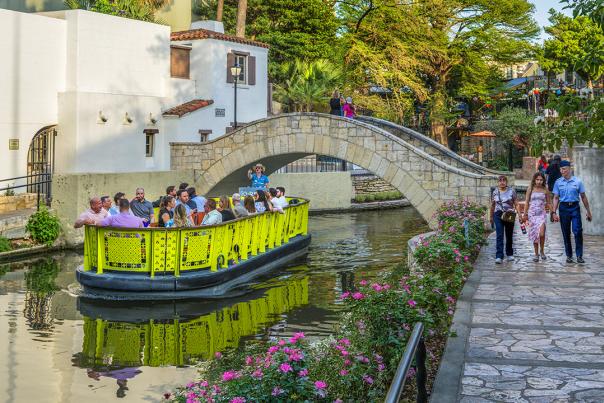 San Antonio River Walk with a barge and Tower of America