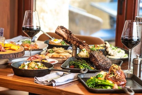 Spread of food with two wine glasses