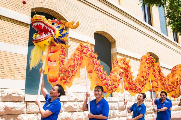 Dragon dancers holding up dragon.