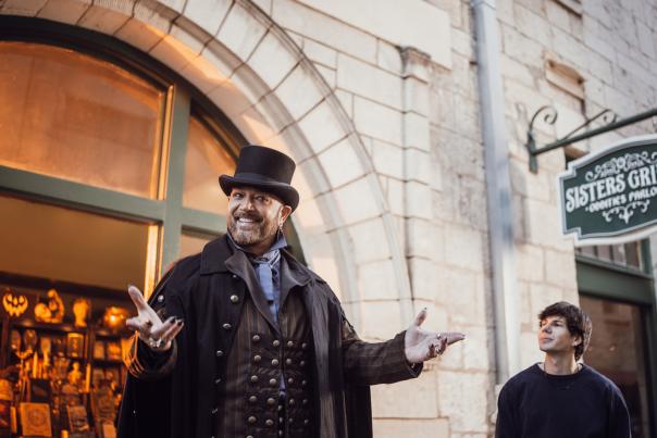 Man presenting story in front of Sisters Grimm signage.